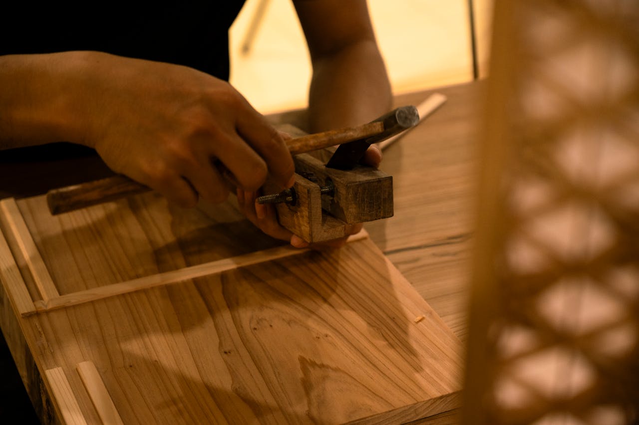 Artisan carefully crafting wood with traditional hand tools, showcasing skill and precision.